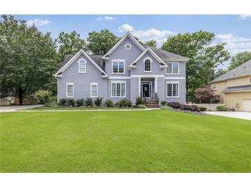 Charming two-story home with a large front lawn and beautiful landscaping at 1634 Crittenden Ln, Lawrenceville, GA 30043