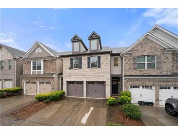 Charming brick townhome featuring a two-car garage and well-maintained landscaping at 2069 Brightleaf Way # 123, Marietta, GA 30060