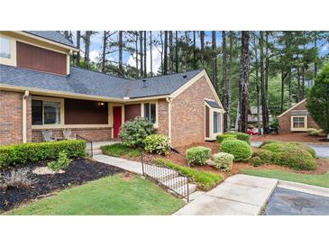 Charming brick townhouse with well-manicured landscaping and inviting front entrance at 49 Country Ct, Alpharetta, GA 30005
