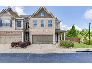 Charming two-story townhome with a brick facade, a two-car garage, and manicured landscaping at , Lawrenceville, GA 30044