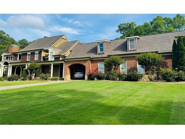 Stunning two-story brick home features a well manicured front yard and attached garage at 1695 Whitley Rd, Dacula, GA 30019