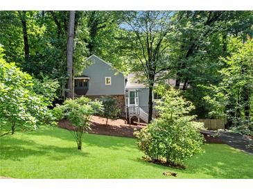 Charming home with a well-maintained front yard and mature trees, creating a serene setting at 3726 Scotts Mill Run, Peachtree Corners, GA 30096