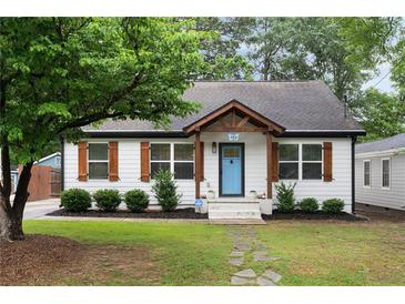 Charming home with a well-maintained lawn, stone pathway, and a delightful blue front door at 3412 Orchard St, Atlanta, GA 30354