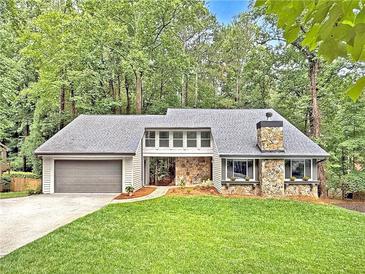 Charming home featuring stone accents, a two-car garage, and a well-manicured front lawn at 2435 Roxburgh Dr, Roswell, GA 30076