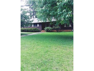 Charming single-story home featuring a well-manicured lawn and lovely landscaping at 5475 Morning Creek Cir, Atlanta, GA 30349