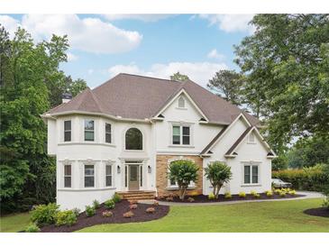 Elegant two-story home featuring a stone accent, manicured lawn, and a welcoming entrance at 5535 Buck Hollow Dr, Alpharetta, GA 30005