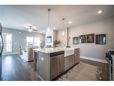 Open-concept kitchen boasts stainless appliances and a central island with views of the living area at 1741 Prospect Way, Conyers, GA 30094