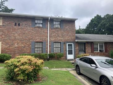 Brick multifamily with gray shutters, trimmed bushes, and a gray car parked in front at 6354 Shannon Pkwy # 26C, Union City, GA 30291