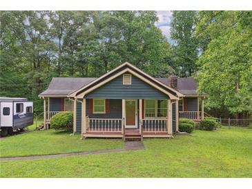 Charming home featuring a cozy front porch, complemented by lush greenery, and a neatly maintained lawn at 160 Northside Ave, Dallas, GA 30157