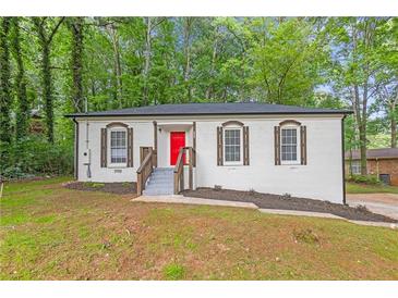Charming, renovated brick ranch home with red front door and new landscaping at 4698 Fellsridge Dr, Stone Mountain, GA 30083