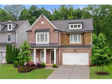 Charming brick home with a covered front porch, manicured landscaping, and a two-car garage at 281 Green Hill Rd, Atlanta, GA 30342