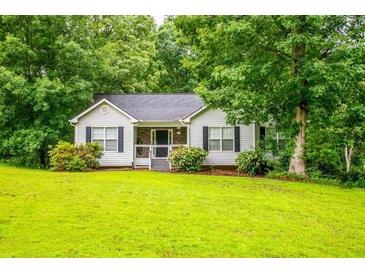 Charming single-story home with lush lawn and mature trees at 305 Saddle Wood Dr, Canton, GA 30114