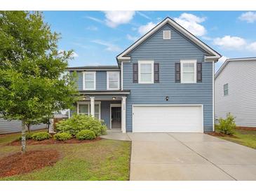 Charming two-story home with blue siding, manicured lawn, and attached two-car garage at 3699 Broadwick Ln, Lithonia, GA 30038