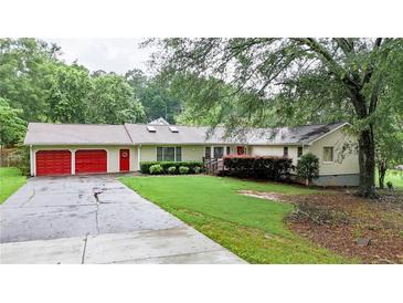 Charming ranch-style home with red garage doors and lush greenery at 4845 Willow St, Acworth, GA 30101
