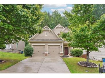 Traditional home featuring a well-manicured lawn, mature trees, and a two-car garage at 2366 Proctor Creek Enclave, Acworth, GA 30101
