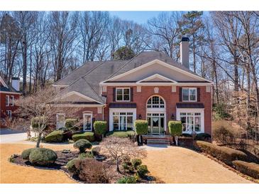 Inviting brick home featuring manicured landscaping, mature trees, and traditional architectural details at 3410 Kates Way, Duluth, GA 30097