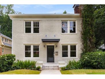 Charming two-story home featuring a brick facade, well-manicured lawn, and inviting front entrance at 851 Courtenay Ne Dr, Atlanta, GA 30306
