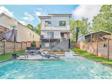 An inviting pool with lounge chairs, surrounded by a wooden fence and lush greenery at 120 Vanira Se Ave, Atlanta, GA 30315