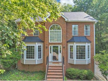 Charming two-story brick home with a large front window, bay windows, and landscaped front yard at 1625 Clark Lake Nw Dr, Acworth, GA 30102
