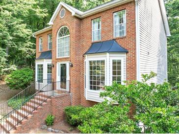 A two-story red brick house with black trim and manicured landscaping at 1625 Clark Lake Nw Dr, Acworth, GA 30102