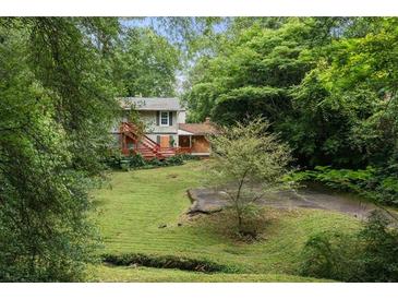 Two-story home with a red deck surrounded by lush greenery and a well-maintained lawn at 998 Northrope Ne Dr, Atlanta, GA 30324
