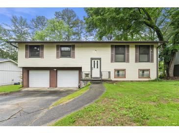 Charming split-level home featuring a two-car garage and front yard at 2501 Northbrook Rd, Snellville, GA 30039