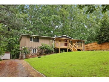 Charming home with a blend of stone and siding, a well-maintained lawn, and a inviting front porch at 3115 Chimney Cove Ln, Cumming, GA 30041