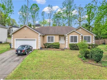Charming single Gathering home showcasing a lush front yard, attached garage and inviting curb appeal at 1574 Glenfield Dr, Lawrenceville, GA 30043