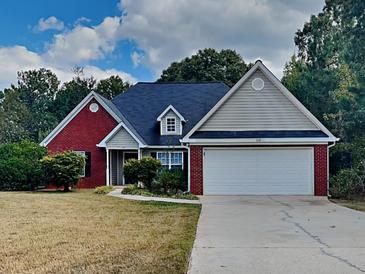 Charming single-Gathering home featuring a two-car garage, beautiful lawn and mature trees at 115 Hugh Dr, Covington, GA 30016