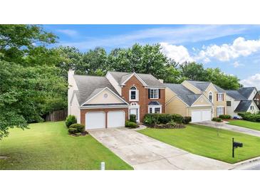 Charming two-story home featuring a well-manicured lawn, brick accents, and a two-car garage at 3614 Clearbrooke Way, Duluth, GA 30097