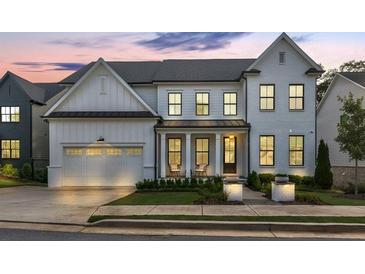 Charming white brick home with a covered porch, well-manicured lawn, and a two-car garage at 401 Pirkle Ave, Buford, GA 30518