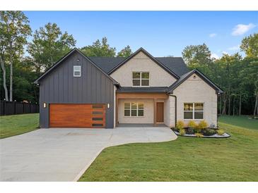 Charming home featuring a mix of brick and board-and-batten siding, and a well-manicured lawn at 859 N Bay Overlook, Villa Rica, GA 30180