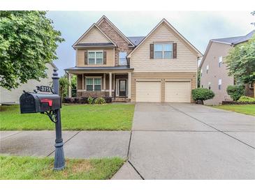 Beautiful two-story home featuring a stone facade, front porch, two-car garage, and well-manicured lawn at 3758 Lake Haven Way, Atlanta, GA 30349