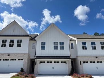 Beautiful townhome with white siding, brick accents, and a two-car garage in a desirable neighborhood at 2409 Malster Ln, Lawrenceville, GA 30043