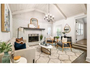 Bright living room with white-painted brick fireplace, modern chandelier, and lots of natural light at 1002 Forrest Blvd, Decatur, GA 30030