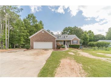 Charming brick home featuring an attached garage, landscaped yard, and inviting front entrance at 1623 Pratt Rd, Covington, GA 30014