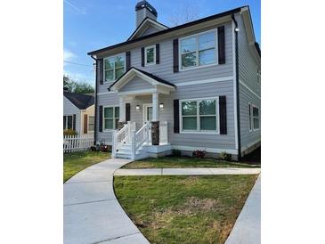 Charming two-story home with gray siding, dark shutters, and a welcoming front porch at 2668 Memorial Se Dr, Atlanta, GA 30317