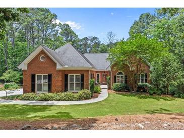 Charming brick home features a well-manicured lawn and mature trees, offering great curb appeal at 25 Highlands Way, Oxford, GA 30054