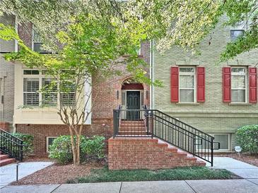 Charming townhouse with brick facade, red shutters, and an inviting front entrance with beautiful landscaping at 2766 Wander Ln, Alpharetta, GA 30022