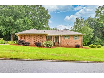 Charming brick home with manicured lawn, mature trees, and a welcoming entrance at 8140 Wood St Se, Covington, GA 30014
