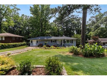 Charming single-story home with a well-manicured lawn and mature trees at 553 Collingwood Dr, Decatur, GA 30032
