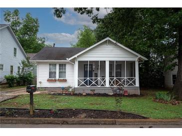 Charming home with a white exterior, inviting screened-in porch, and well-maintained front yard at 3116 Jackson St, Hapeville, GA 30354