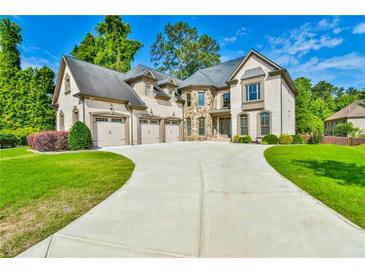 Elegant brick home with a three-car garage and a large, beautifully landscaped front yard at 5121 Hope Sw Ct, Lilburn, GA 30047
