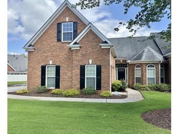 Charming brick home featuring black shutters, lush lawn, and professionally landscaped front yard at 5250 Villa Lake Ct, Suwanee, GA 30024