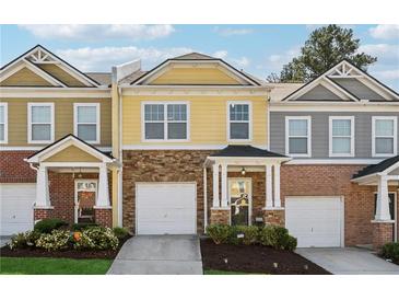 Charming two-story townhome with brick and siding accents and a one-car garage at 771 Arbor Gate Ln, Lawrenceville, GA 30044
