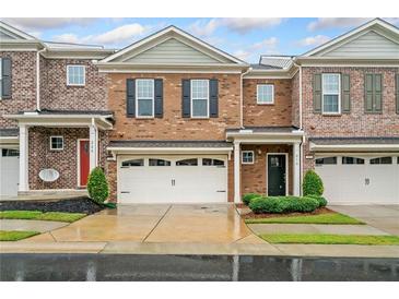 Charming townhome with a one car garage and manicured front lawn at 218 Ellis Ln, Woodstock, GA 30189