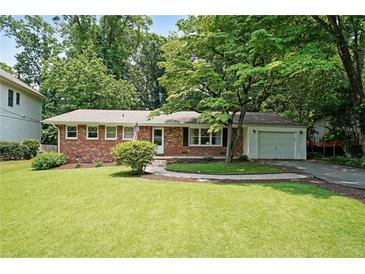 Charming brick home with well-maintained lawn, mature trees, and a one-car garage at 2394 Burch Ne Cir, Brookhaven, GA 30319