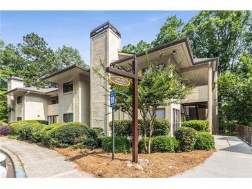 Charming condo complex with lush landscaping, mature trees and welcoming signage at 408 Coleraine Se, Smyrna, GA 30080