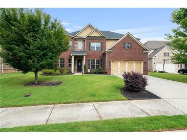 Lovely two-story brick home with a well-manicured lawn, mature trees, and a two-car garage at 3352 Stone Point Way, Buford, GA 30519