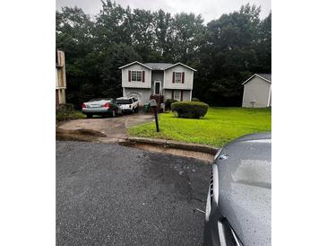 Charming two-story home featuring gray siding, red shutters, and a well-maintained front lawn at 5568 Bradley Cir, Lithonia, GA 30038